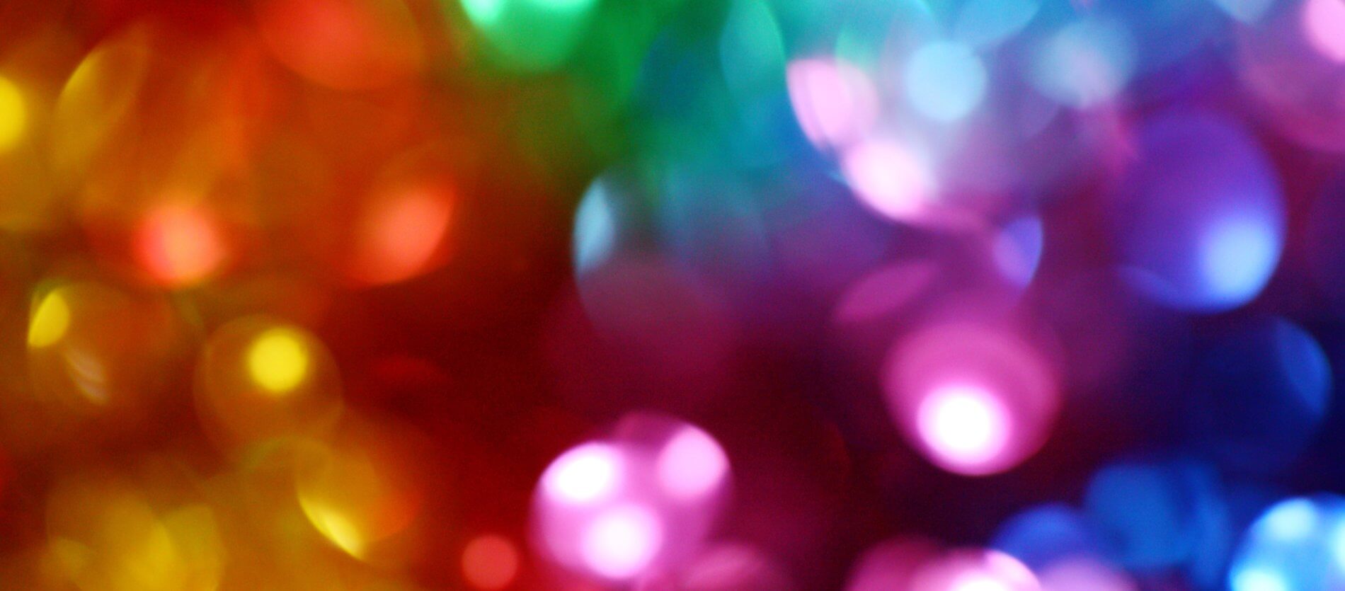 Unfocussed image of multi-coloured lights ranging from yellow through to purple