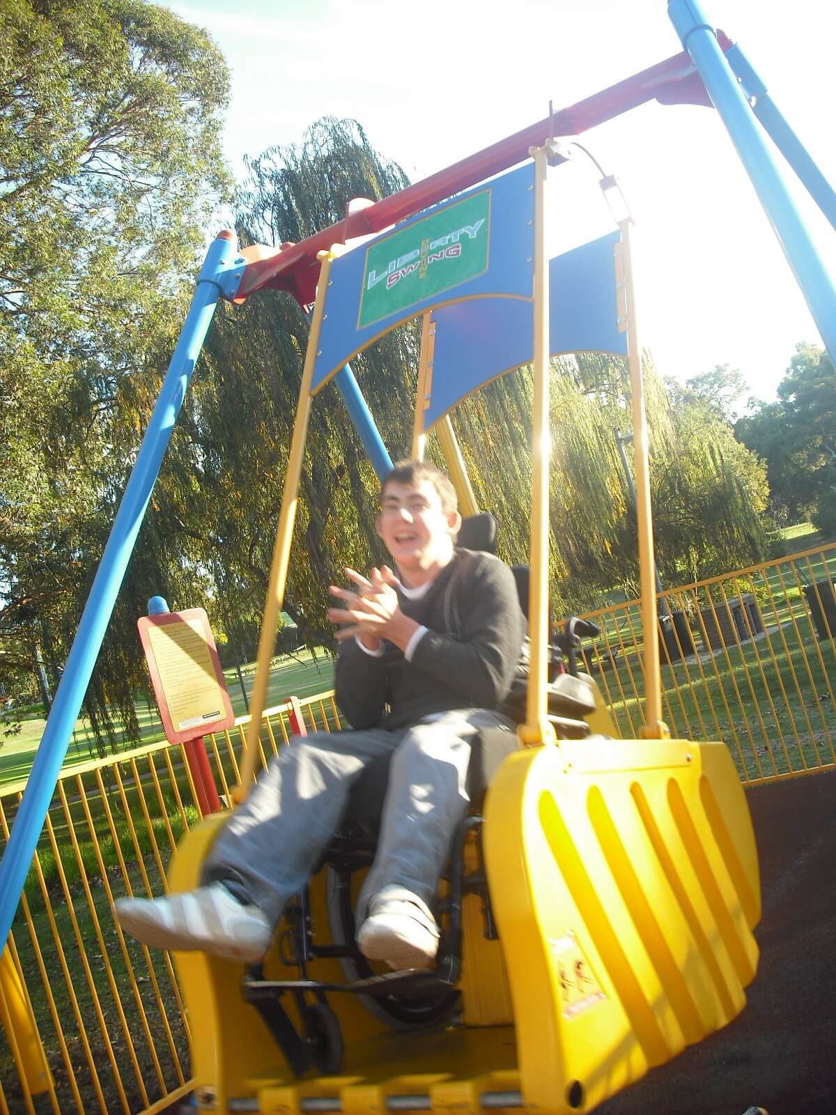 A person clapping while using the Liberty Swing located at Stirk Park in Kalamunda