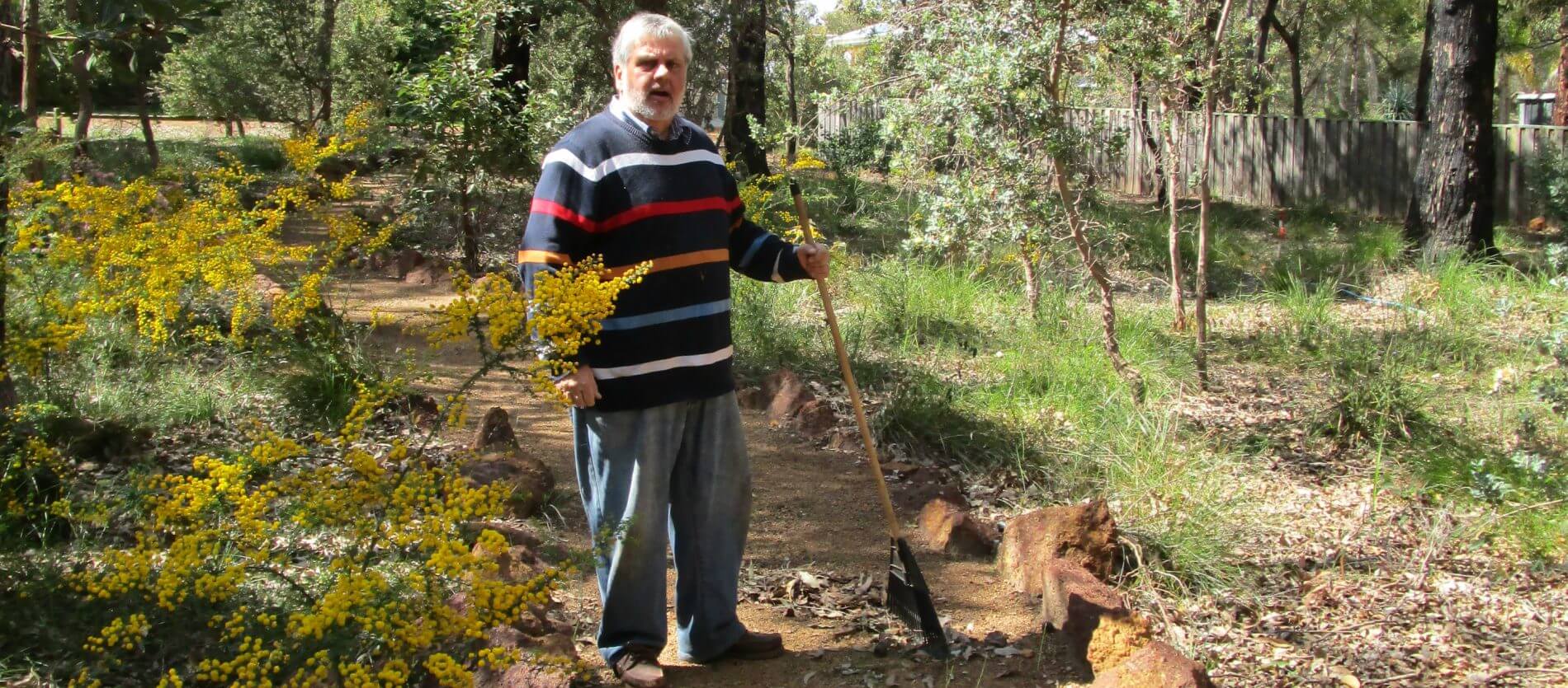 Male volunteer with a rake at Vernallen Reserve