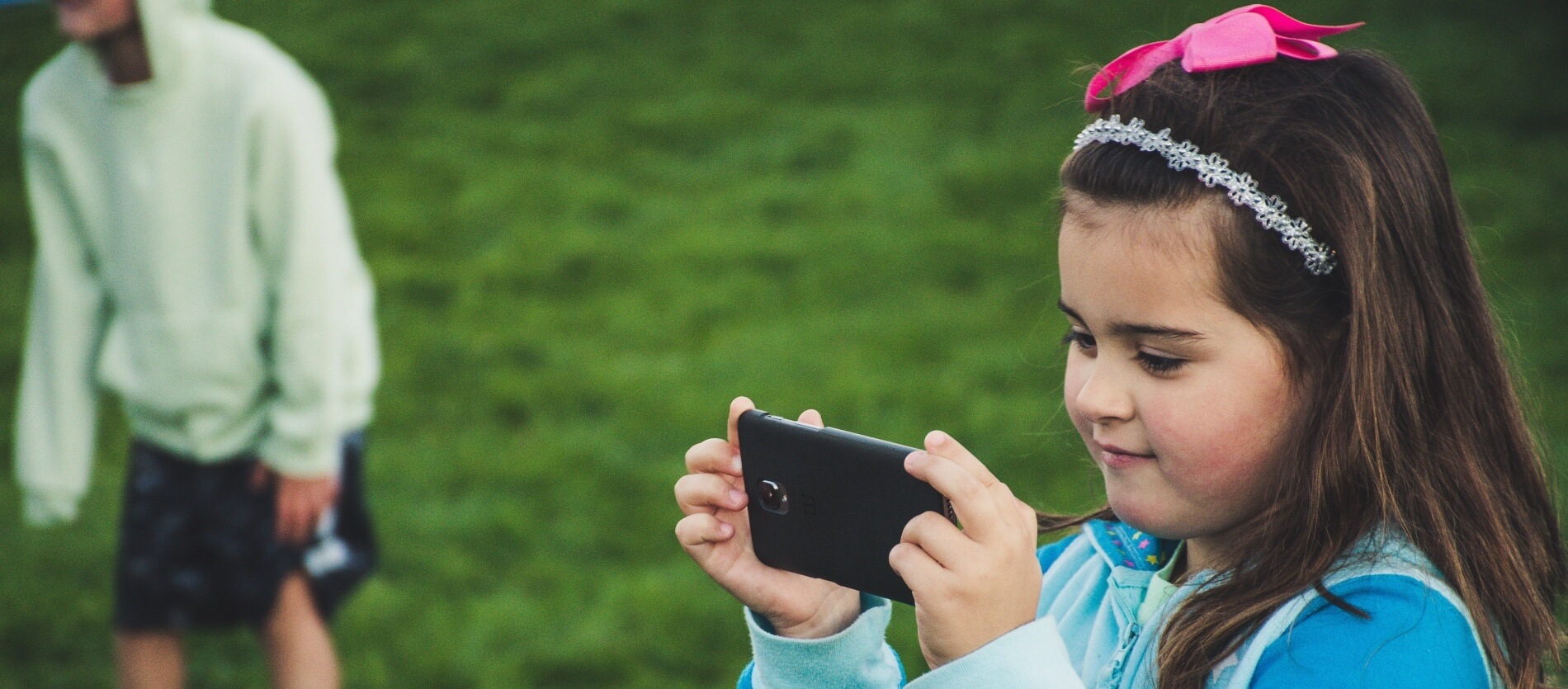 A young girl using a smartphone outside